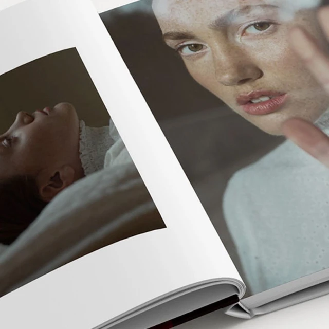 Open magazine spread featuring close-up portrait of a fair-skinned adult female looking at camera and another of a reclining person.