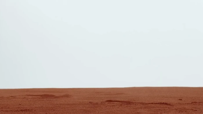 Minimal landscape photograph showing a smooth reddish-brown terrain against an overcast pale sky in Paris by Laurent Seroussi.