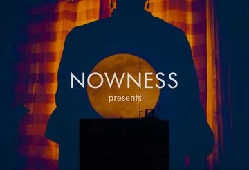 Silhouette of a person against an orange moon with text overlay 'Nowness presents'.