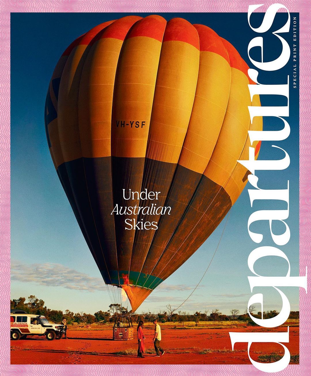 Travel magazine cover featuring a hot air balloon over a desert landscape with people and a safari vehicle on red ground.