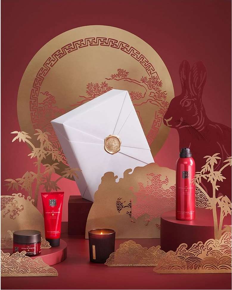 Luxurious beauty product set on a red backdrop with a rabbit and decorative elements, perfect for holiday or festive promotions.