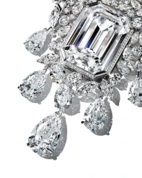 Close-up of an intricate diamond pendant necklace with a large emerald-cut center stone and hanging pear-cut diamonds on white.