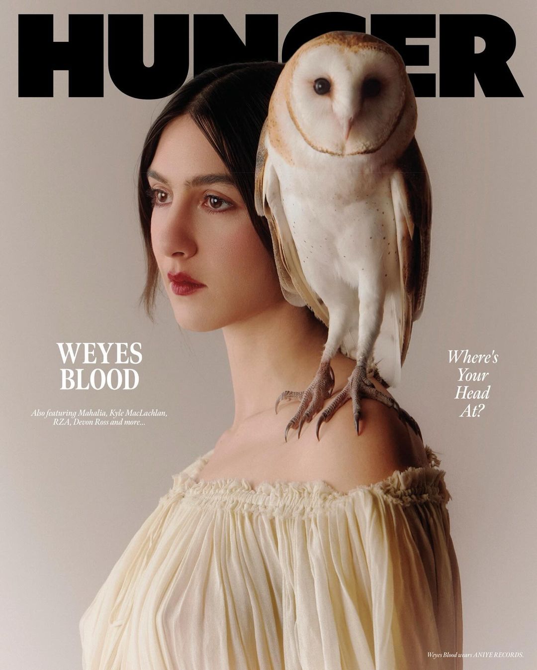 Hunger Magazine cover featuring a woman with dark hair posing with an owl perched on her shoulder. She is wearing a cream-colored dress.