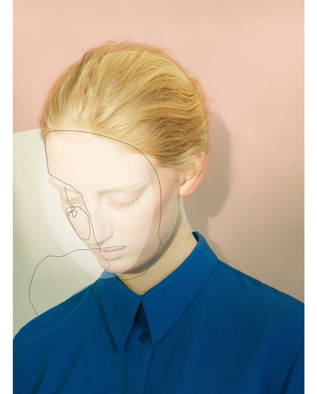 Woman with blonde hair and blue shirt against a pink background with line drawing of a face, soft lighting, and shallow depth of field.