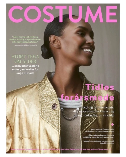 Fashion magazine cover featuring a smiling Black woman in a gold jacket. The Costume magazine promotes a spring fashion edition.