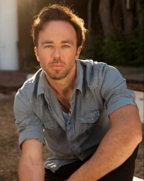 Man with light stubble wearing a blue button-down shirt outdoors in Sydney by United Management.