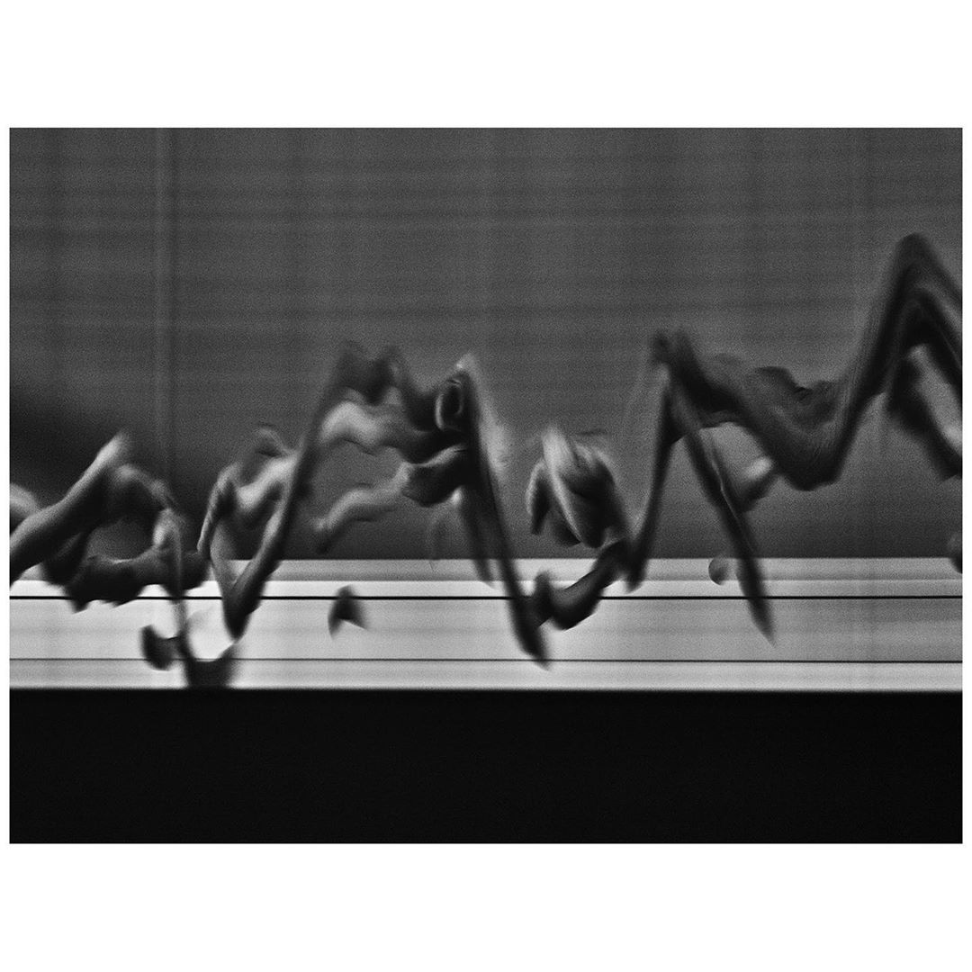 Abstract black and white photograph of swirling shapes in a blurry background, creating a sense of motion and fluidity.