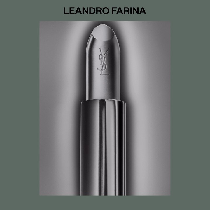 Still life of a single YSL lipstick tube. Shot with shallow depth of field and silver-dominant colors, presented on a blurred background.
