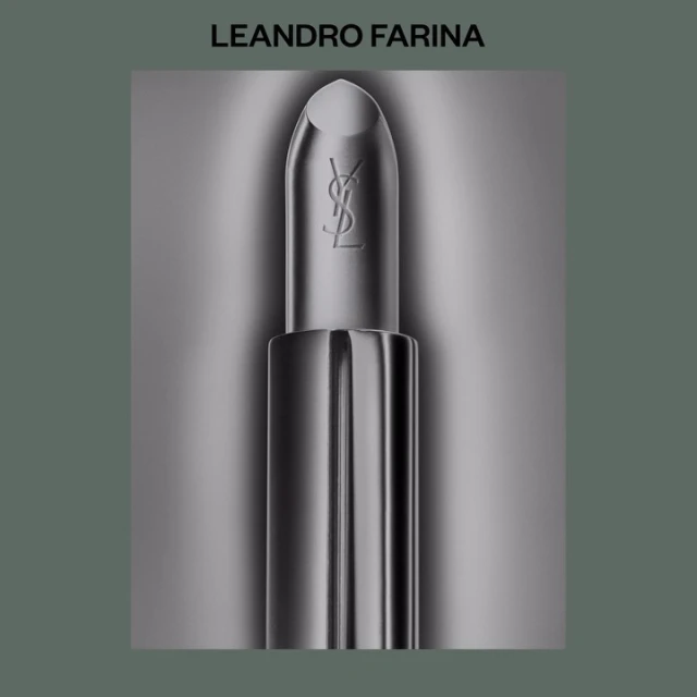 Still life of a single YSL lipstick tube. Shot with shallow depth of field and silver-dominant colors, presented on a blurred background.