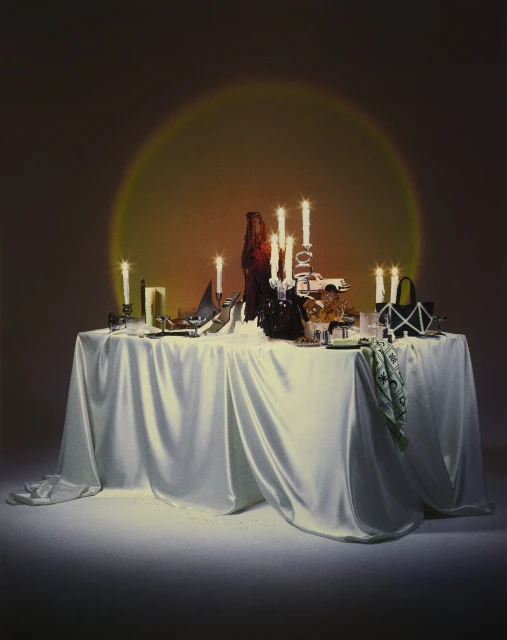 Indoor scene with a table draped in white fabric, adorned with candles, dishes, and decorative items, illuminated by a golden light source.