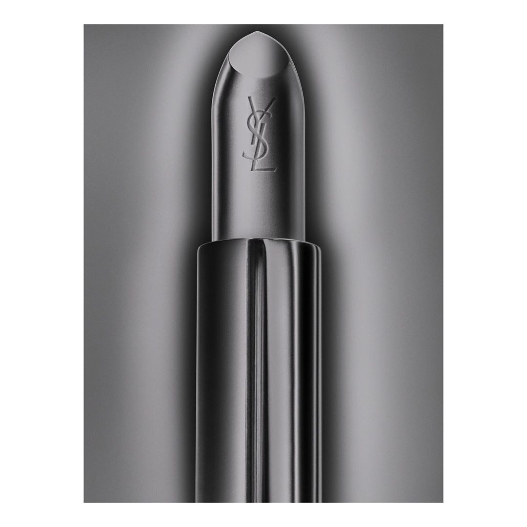 Close-up studio shot of YSL lipstick with a silver metallic finish, showcasing the brand logo against a blurred grey background.