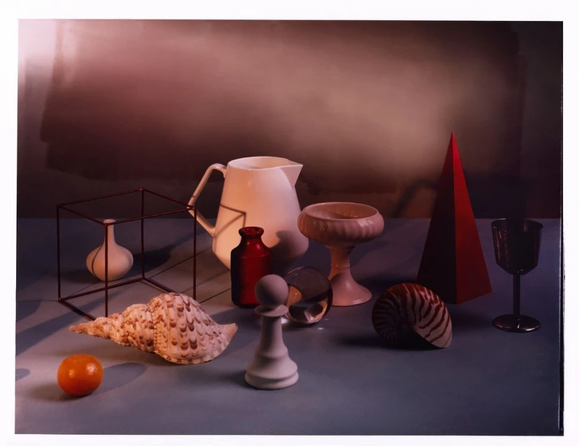 Still life featuring a pitcher, various containers, a seashell, and a red pyramid against a gradient background.