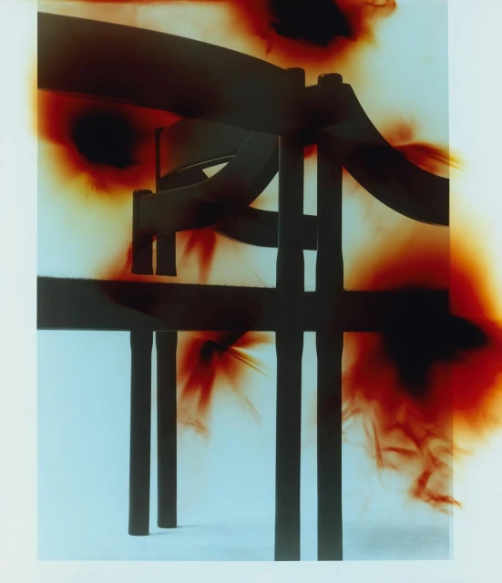 Abstract composition featuring an artistic rendering of a modern chair silhouetted against a gradient background with red and white hues.
