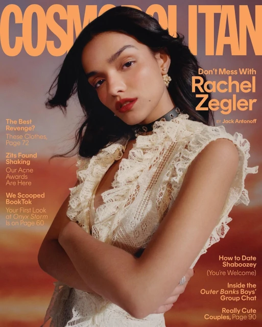 Cosmopolitan magazine cover featuring Rachel Zegler in a ruffled white top against a sunset-toned background, with magazine text overlay.