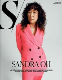Portrait of Sandra Oh wearing a bright pink double breasted blazer against a seamless white background by Leeor Wild