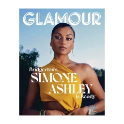 Portrait of Simone Ashley wearing a sleeveless yellow top and gold bracelets against an outdoor background with clear sky