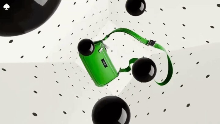 A lime green shoulder bag with a silver clasp floats in a white cube with black dot pattern and several black, round, shiny orbs.