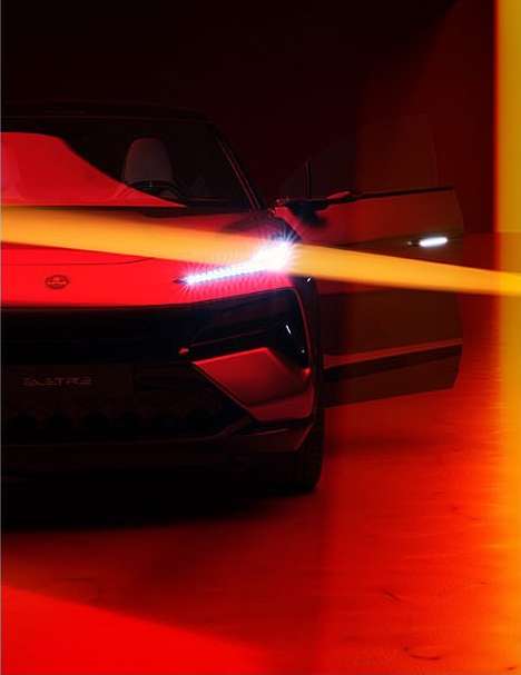 Front view of a black electric car in a studio setting with its door open and a yellow light streak across the hood.