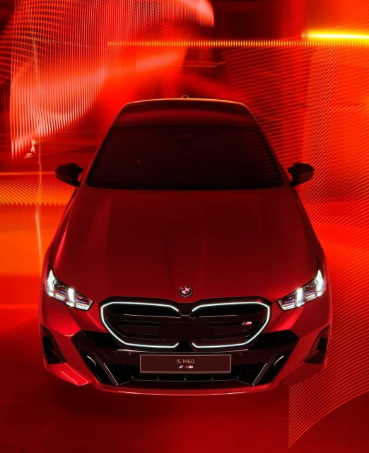 Front view of a red BMW 5 M60 car with a red and black grill and a red abstract background, automotive photography.