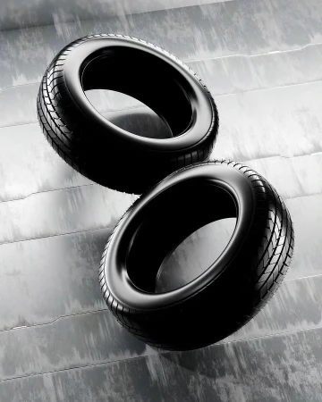Two black tires are stacked on a gray surface with horizontal lines, showcasing a modern automotive or industrial product display.