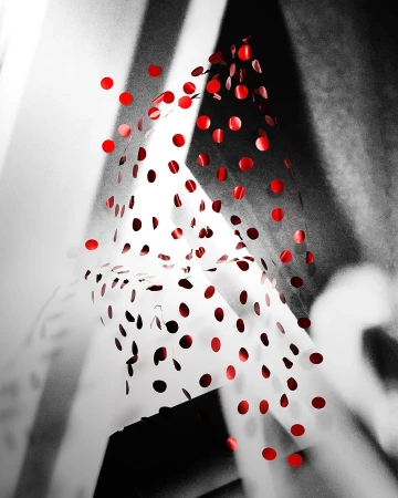 Abstract composition with falling red confetti against a monochrome geometric background. Red dots in dynamic motion.