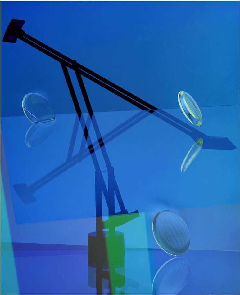 Abstract studio shot with modern black lamp, floating translucent discs, blue background, and reflections. Lighting and interior design.
