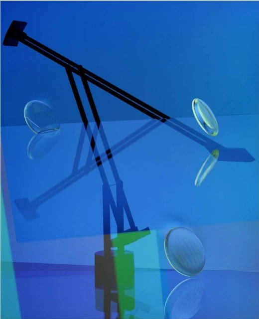 Abstract studio shot with modern black lamp, floating translucent discs, blue background, and reflections. Lighting and interior design.