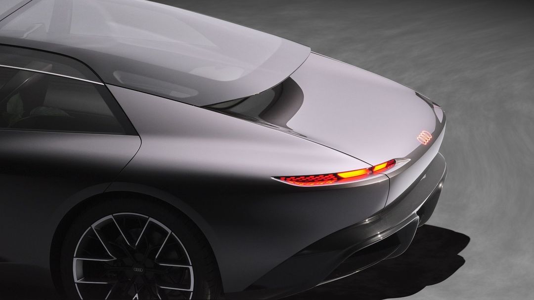 Rear view of a grey Audi concept car highlighting its sleek design, rear lights, and wheel. Car photography for Automotive industry.