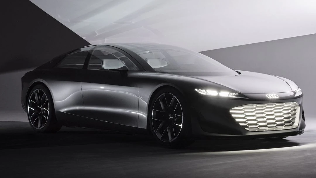 Sleek silver Audi concept car with illuminated grill and black wheels in a dimly lit studio. Automotive design and modern transport.