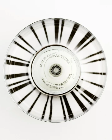 Overhead shot of a striped white and black round container with N.C.P. Olfactives label and silver accents on a plain white backdrop.