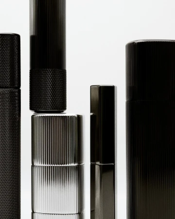 Still life of black and silver cylinders against a white background, showcasing their metallic textures and sleek, modern designs.