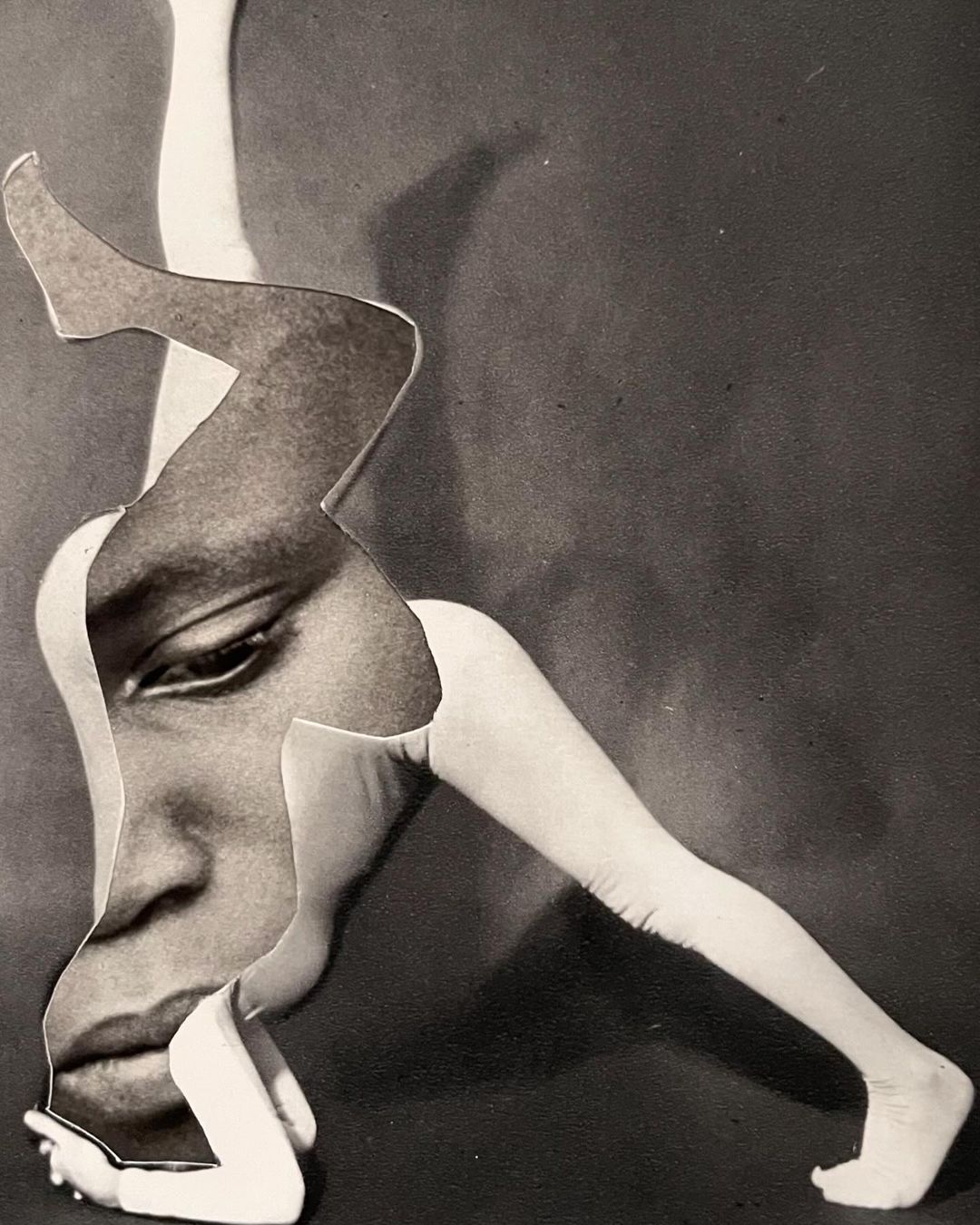 Collage of an African American face with white legs in a dynamic pose, set against a dark gray background. High contrast and striking visual.