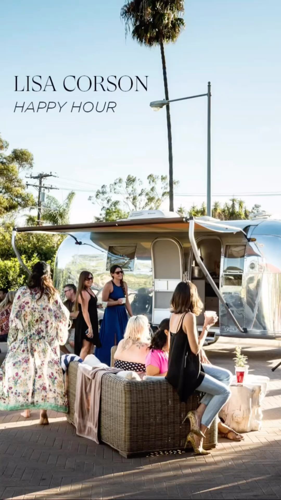 Outdoor social gathering in front of an Airstream trailer, featuring a group of people and a sunny, casual atmosphere.