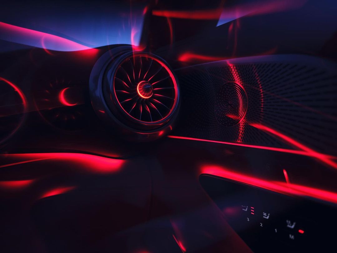 Interior shot of a car dashboard and console featuring illuminated buttons, red light accents, and a textured speaker.