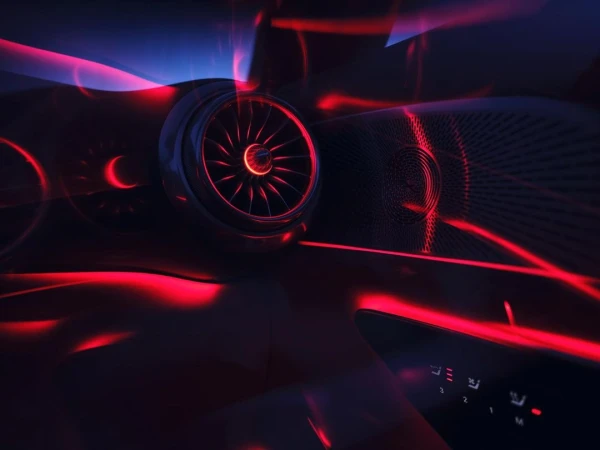 Interior shot of a car dashboard and console featuring illuminated buttons, red light accents, and a textured speaker.