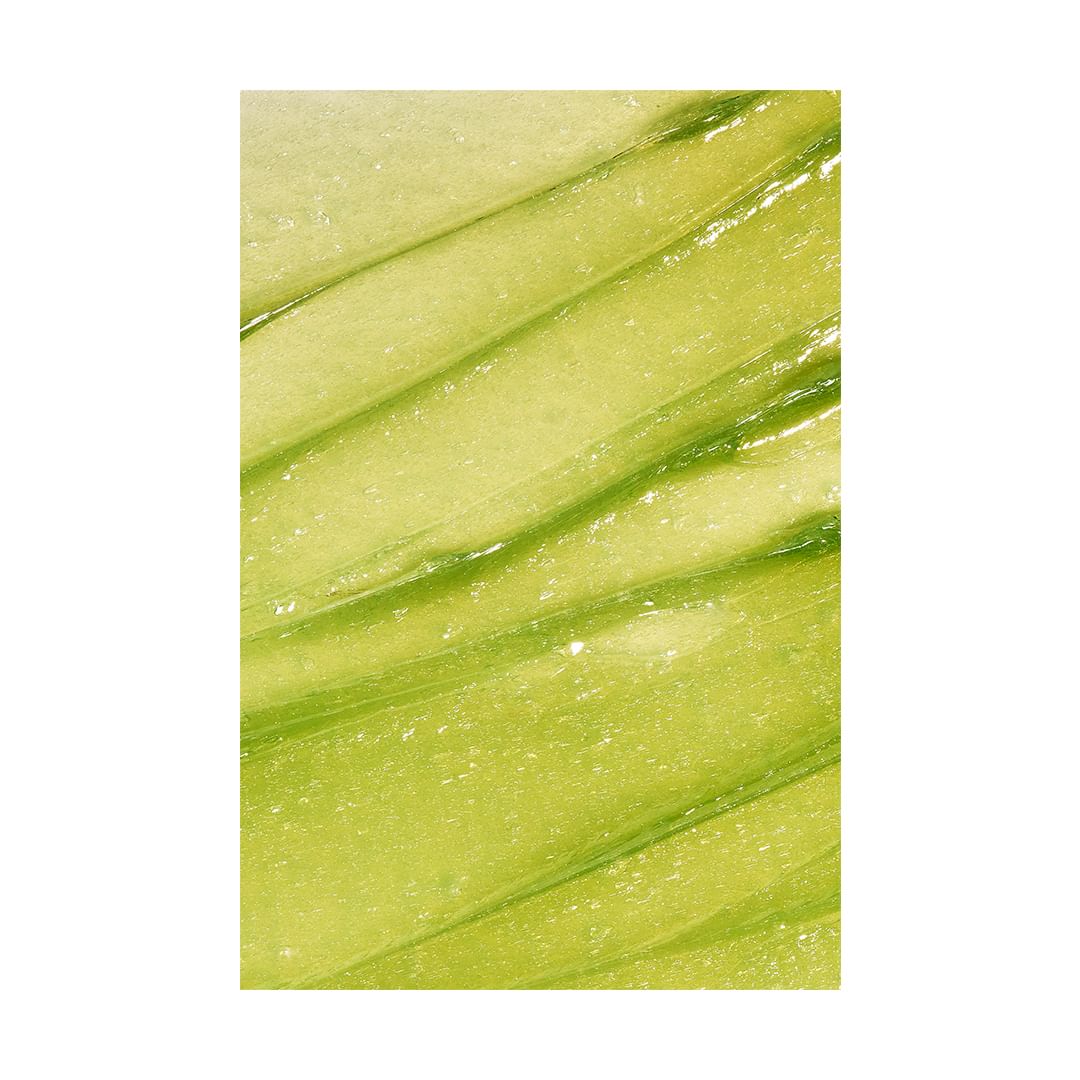 Macro shot of a light green cosmetic product with lines, showcasing its texture and color.