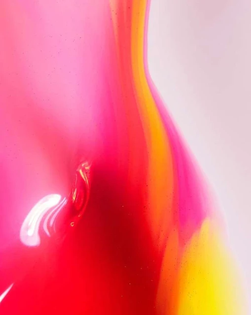 Fluid art abstract background featuring a blend of pink, red, and yellow colors creating a vibrant and dynamic composition.
