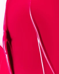 Close-up macro shot of vibrant pink cosmetic product swatch with glossy texture by Lisa Raio