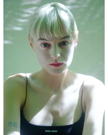 Portrait of a woman with blonde hair wearing a black spaghetti strap top by photographer Liv Liberg