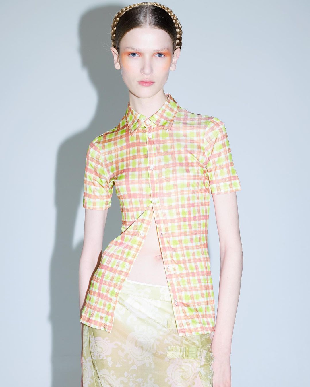 Model wearing a plaid short sleeve button up shirt and braided headband photographed by Liv Liberg against a grey seamless backdrop