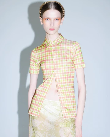 Model wearing a plaid short sleeve button up shirt and braided headband photographed by Liv Liberg against a grey seamless backdrop