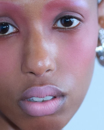Close-up portrait of a woman with pink eyeshadow and pale lips photographed by Liv Liberg in London
