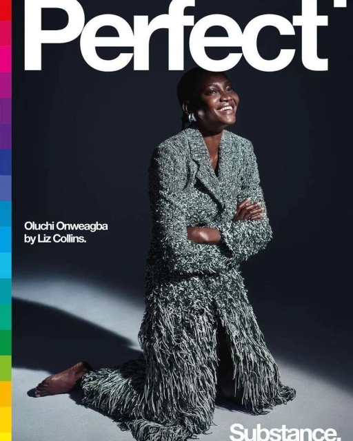 Magazine cover featuring a smiling Black woman in a fringed blazer and skirt, kneeling on a grey surface. Text reads "Perfect."