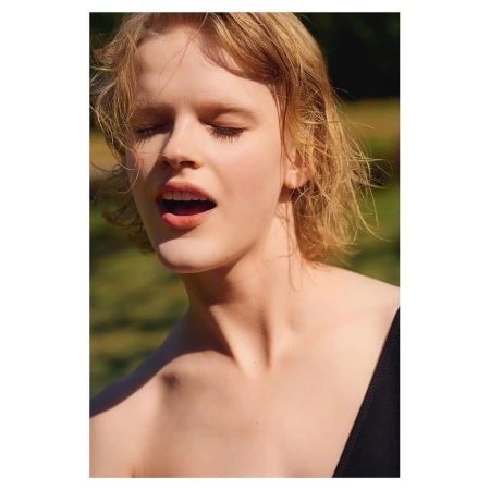 Close-up portrait of a woman with blonde hair, closed eyes, and open mouth outdoors by photographer Liz Collins