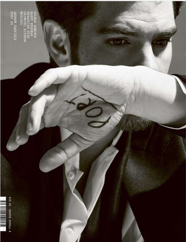 Close-up portrait of Andrew Garfield by photographer Liz Collins, holding his hand with written text over his face.