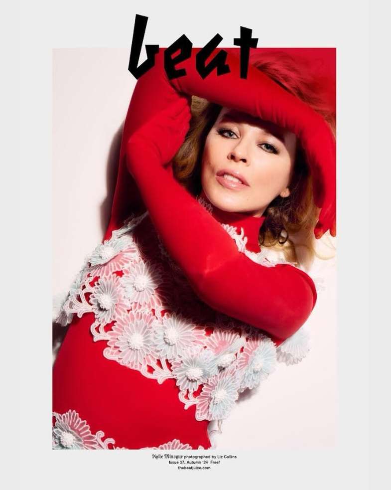 Fashion magazine cover featuring a woman in a red floral dress with long red gloves, set against a pale backdrop.