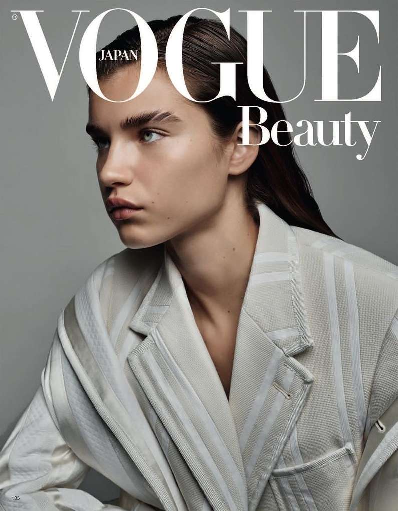 Vogue Japan beauty magazine cover featuring a young adult female model with light skin and dark hair wearing a white striped blazer.