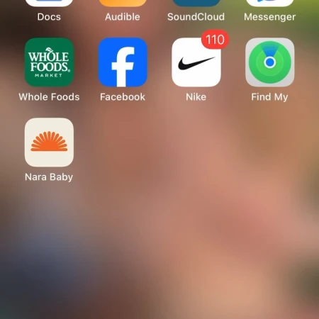 Smartphone home screen showing various app icons including Whole Foods, Facebook, Nike, Find My, and Nara Baby.