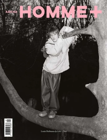 Magazine cover featuring a young man standing on a tree branch in a jacket and pants, with the magazine's title, Arena Homme+.