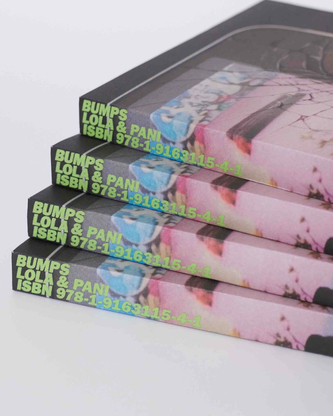 Stack of books featuring colorful cover art and visible ISBN numbers, with a bright background and a focus on artistic publication.